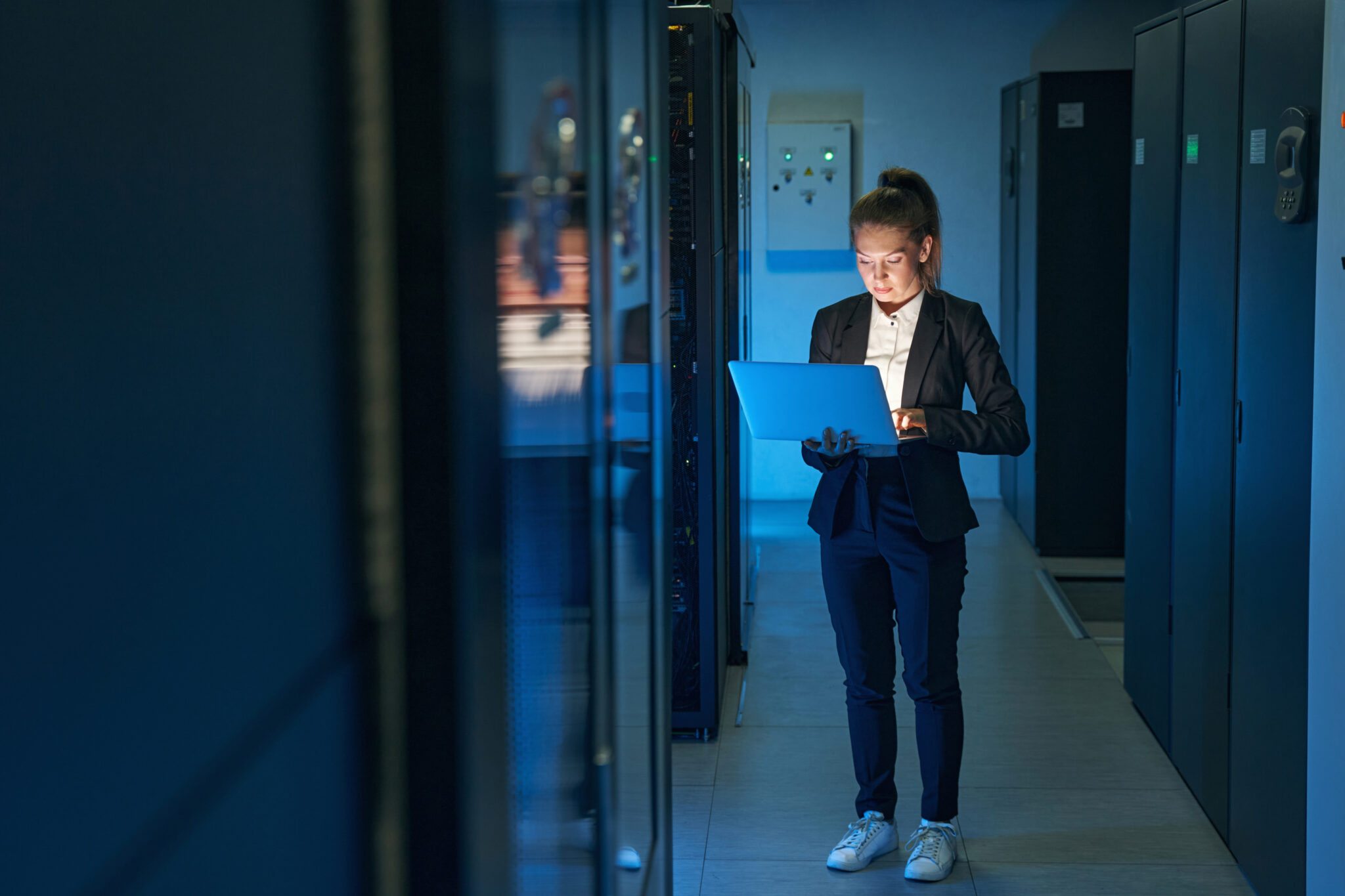 A financial services industry IT security specialist using a tablet in a data center to view IoT data exports from the Cyler Platform that have been integrated with data from other security, compliance, and resource allocation solutions for holistic analysis.