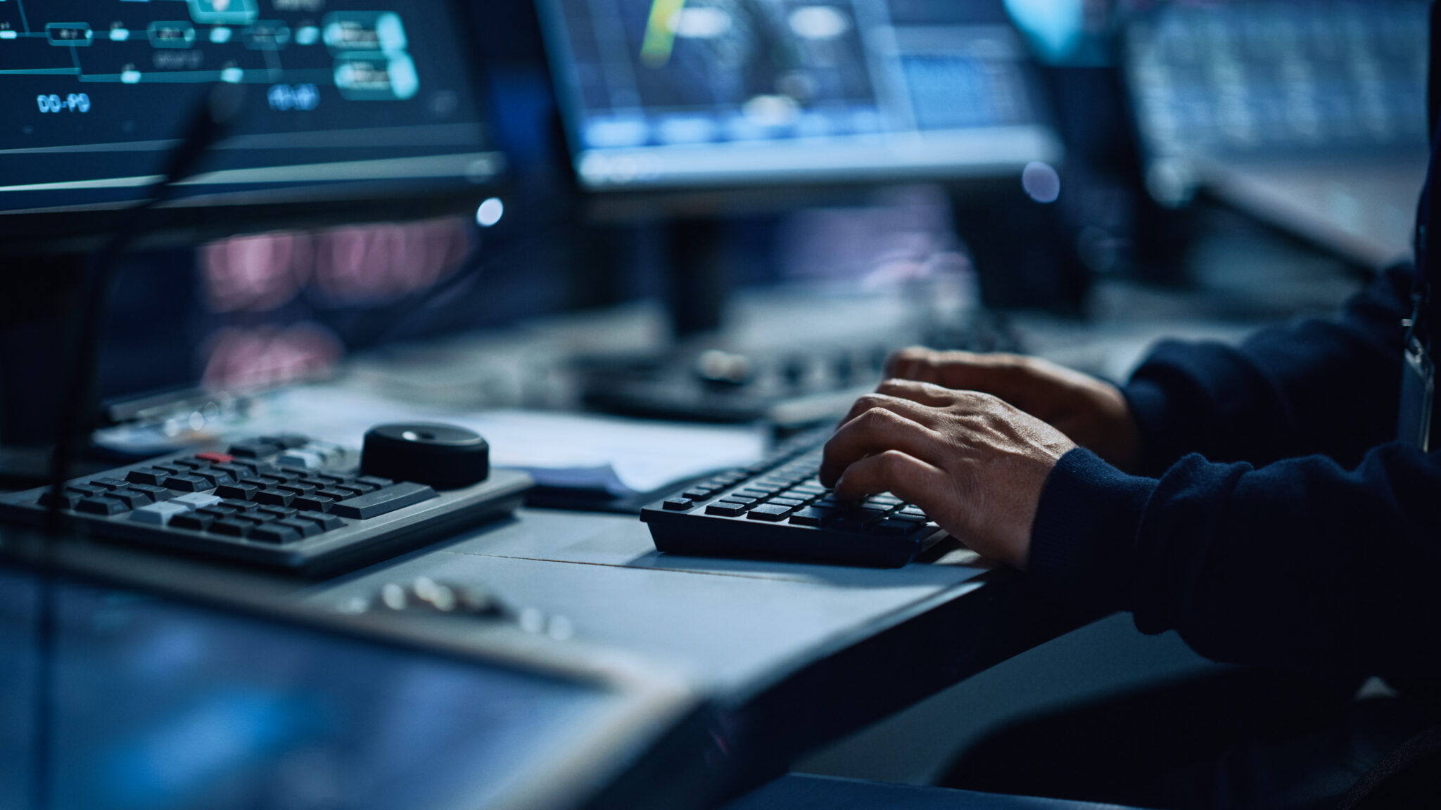 Close-up of a financial services industry IT employee’s hands typing on a keyboard while using Cylera’s platform to view a detailed record of connected IoT assets, which includes information about device manufacturer, firmware, network services, and more.