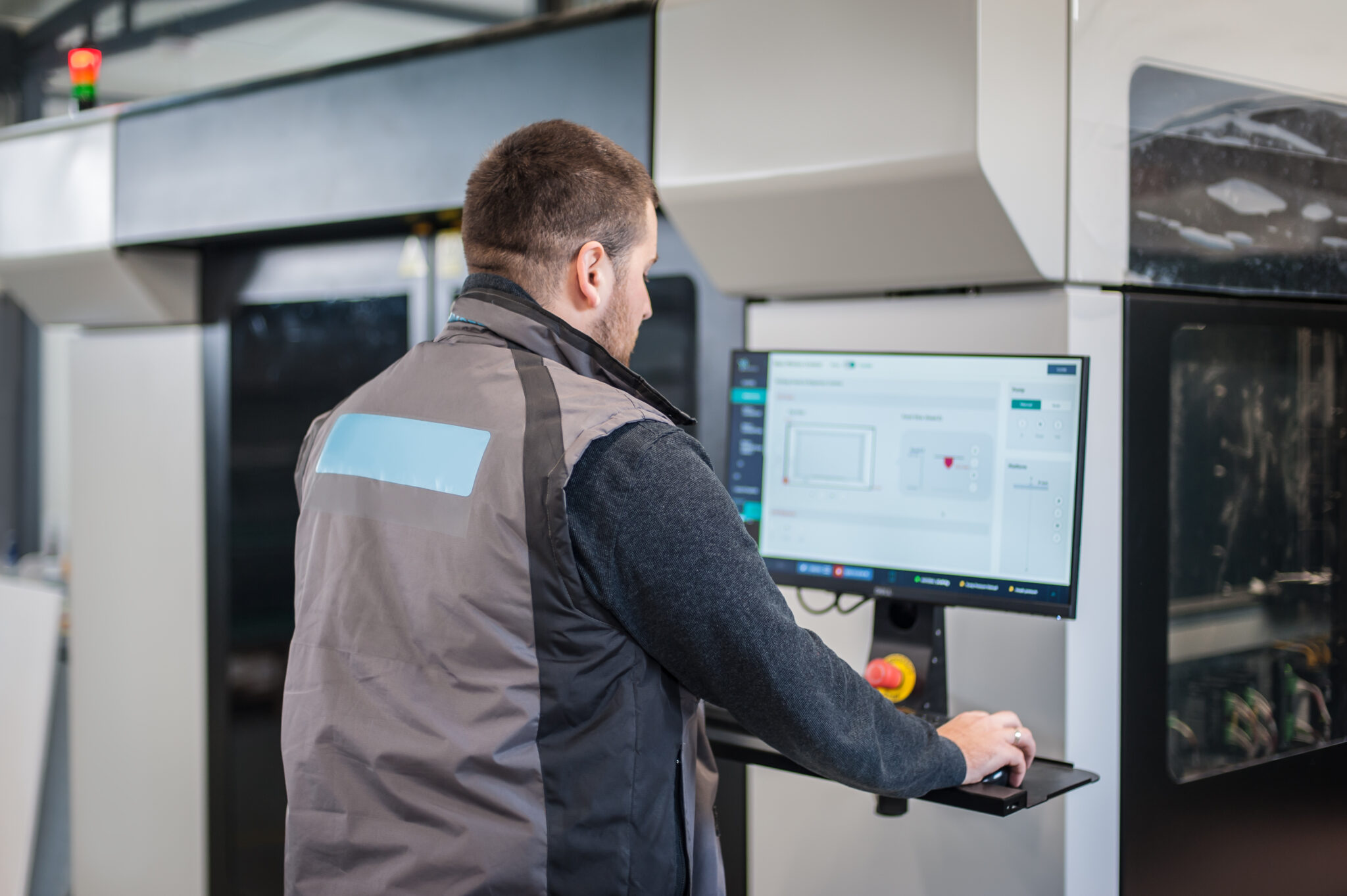 Factory technician working on large IoT connected manufacturing machine, secured and monitored by Cylera’s AI-driven vulnerability and risk management platform.